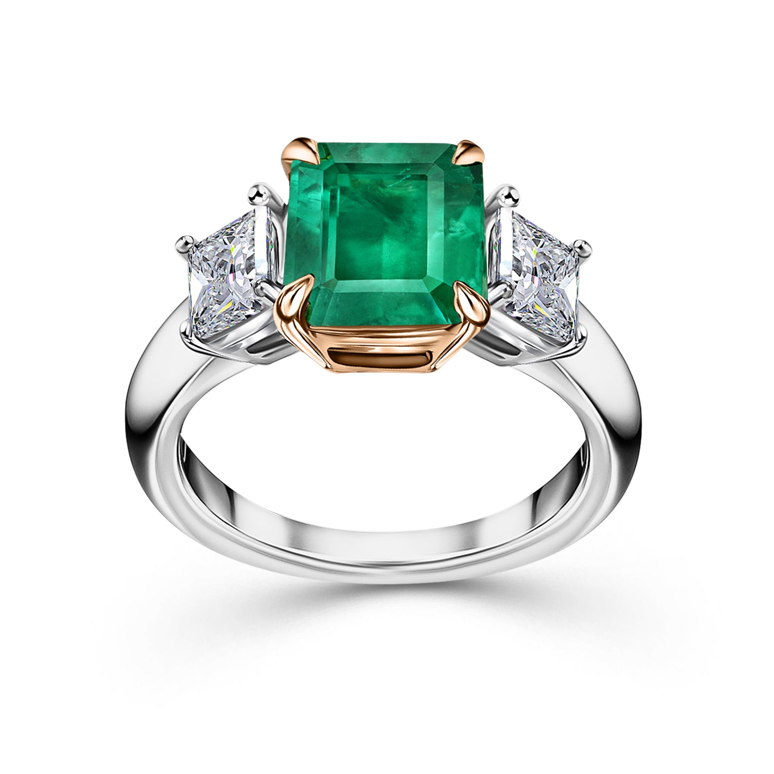 Two-tone three-stone ring with an emerald-cut green emerald center and two princess-cut diamond side stones. Photograph taken at our Jewellery Store in Plymouth.