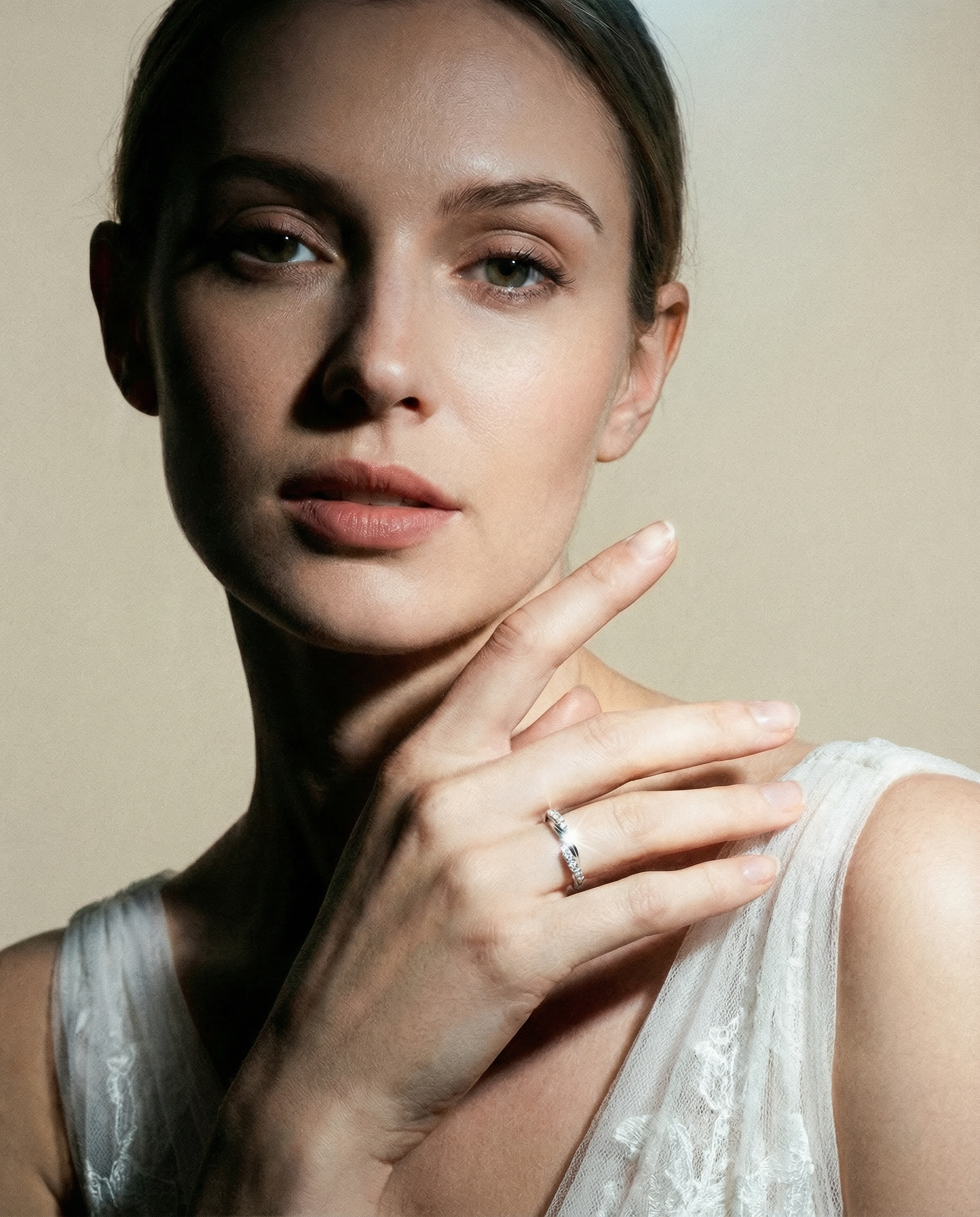 Woman wearing a diamond 18ct gold wedding ring with a beige background