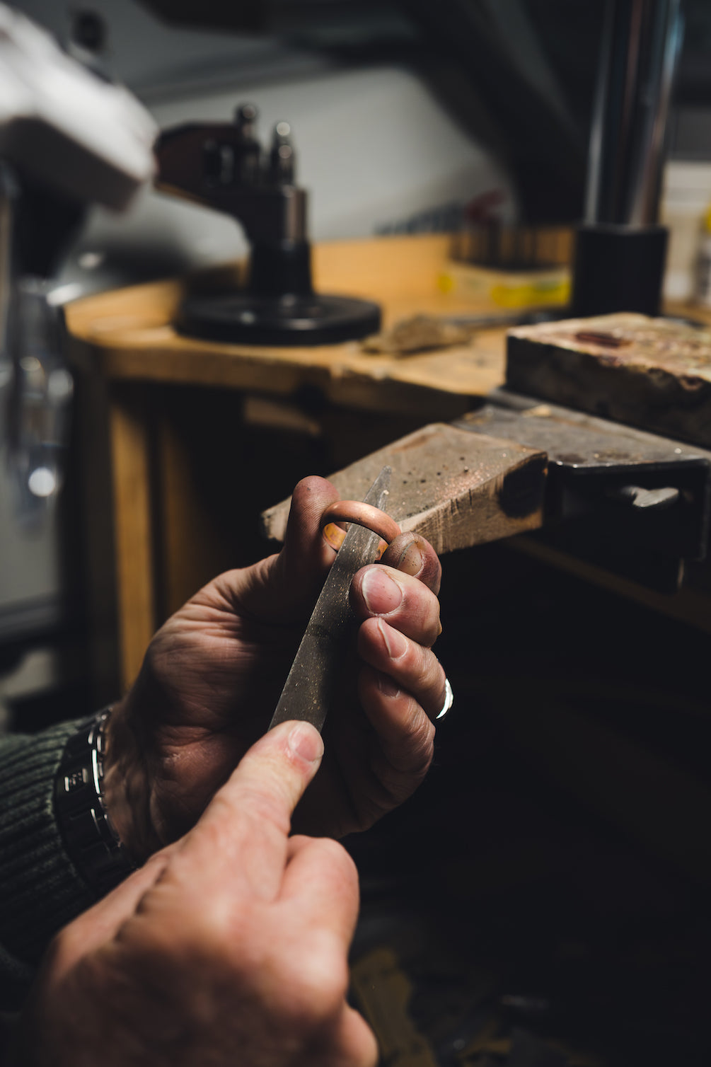 a goldsmith in a jewellers hand-making a wedding ring in gold at our Plymouth Jewellery Store.
