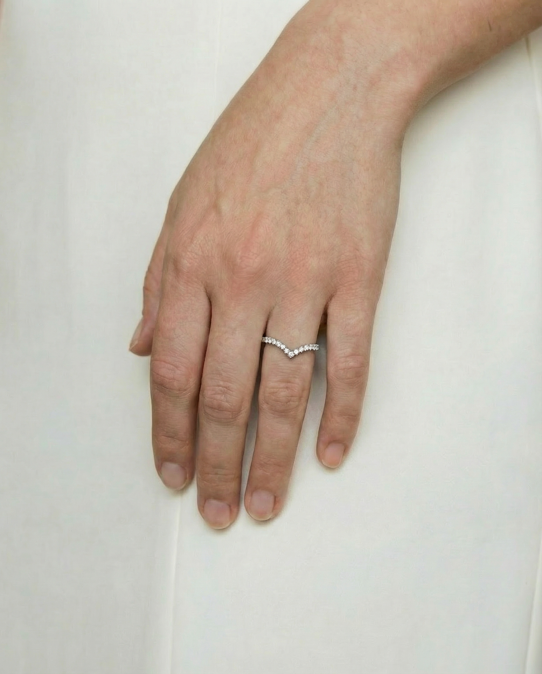 bride's hand wearing a diamond set shaped wedding ring